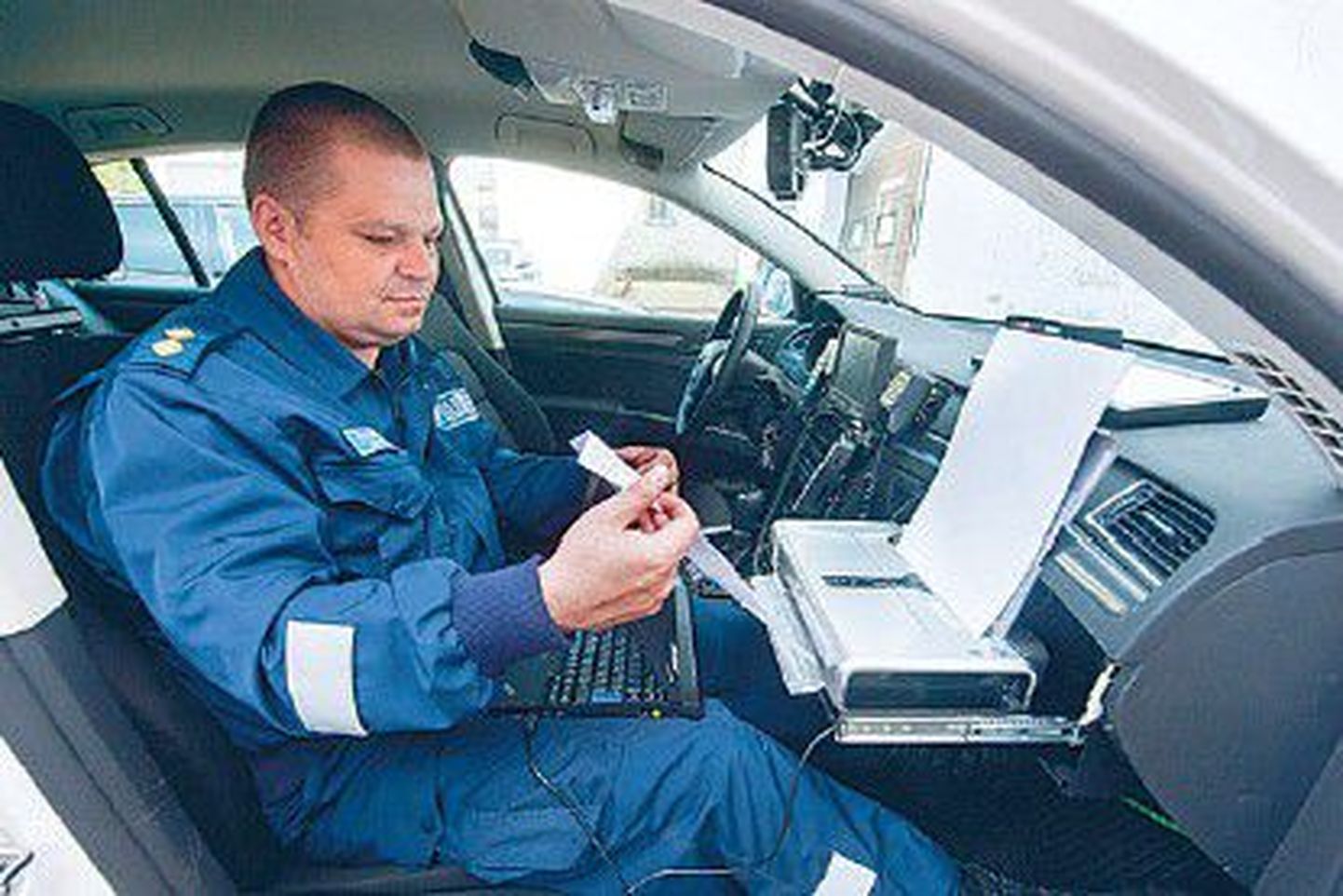 Старший дорожный полицейский Рагнар Янес показывает, как работает ноутбук, которыми будут оснащены большинство патрульных машин.