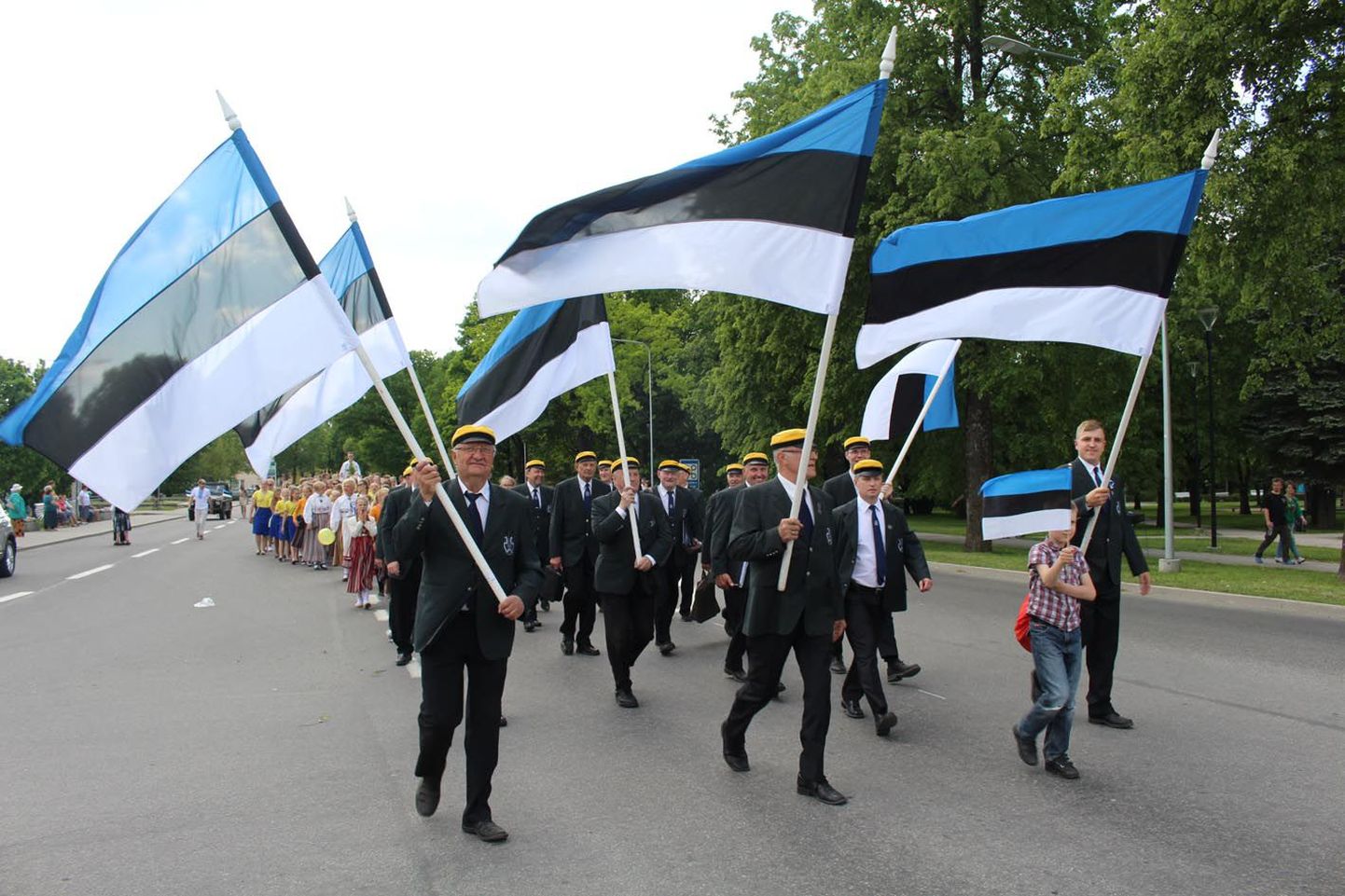 Paide meeskoori liikmed kandsid rongkäigus suuri sinimustvalgeid lippe.