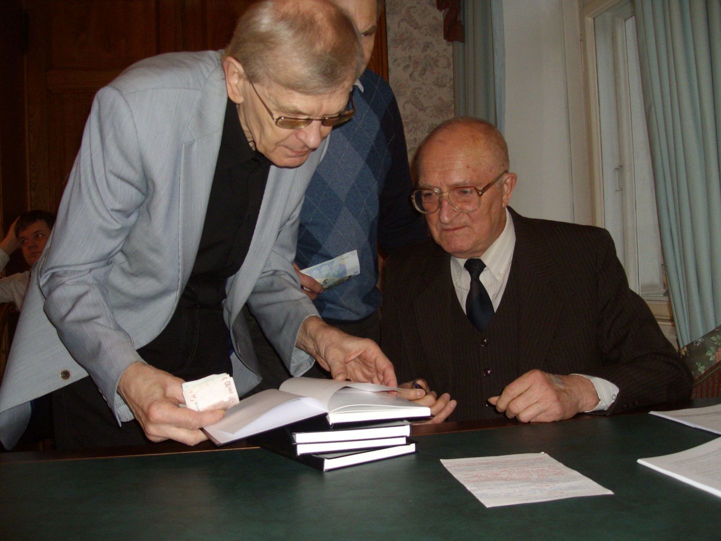Bibliofiil ja filosoof Ülo Matjus (vasakult) küsib Kalev Sikult autogrammi tema äsja ilmunud raamatusse.