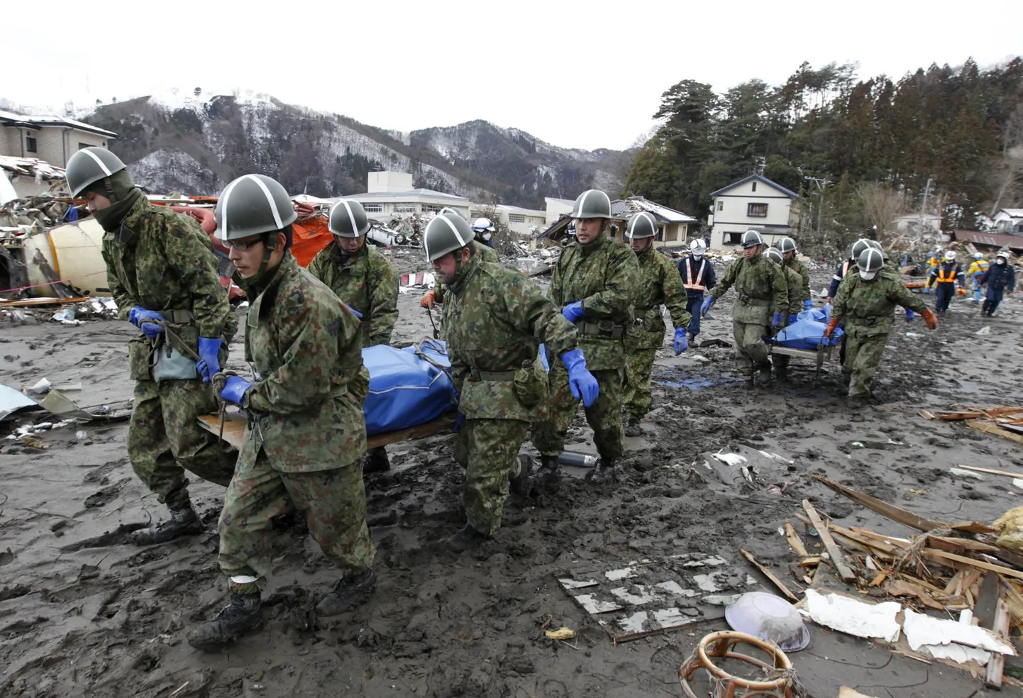 Военнослужащие японской армии выносят тела погибших в городе Оцучи.