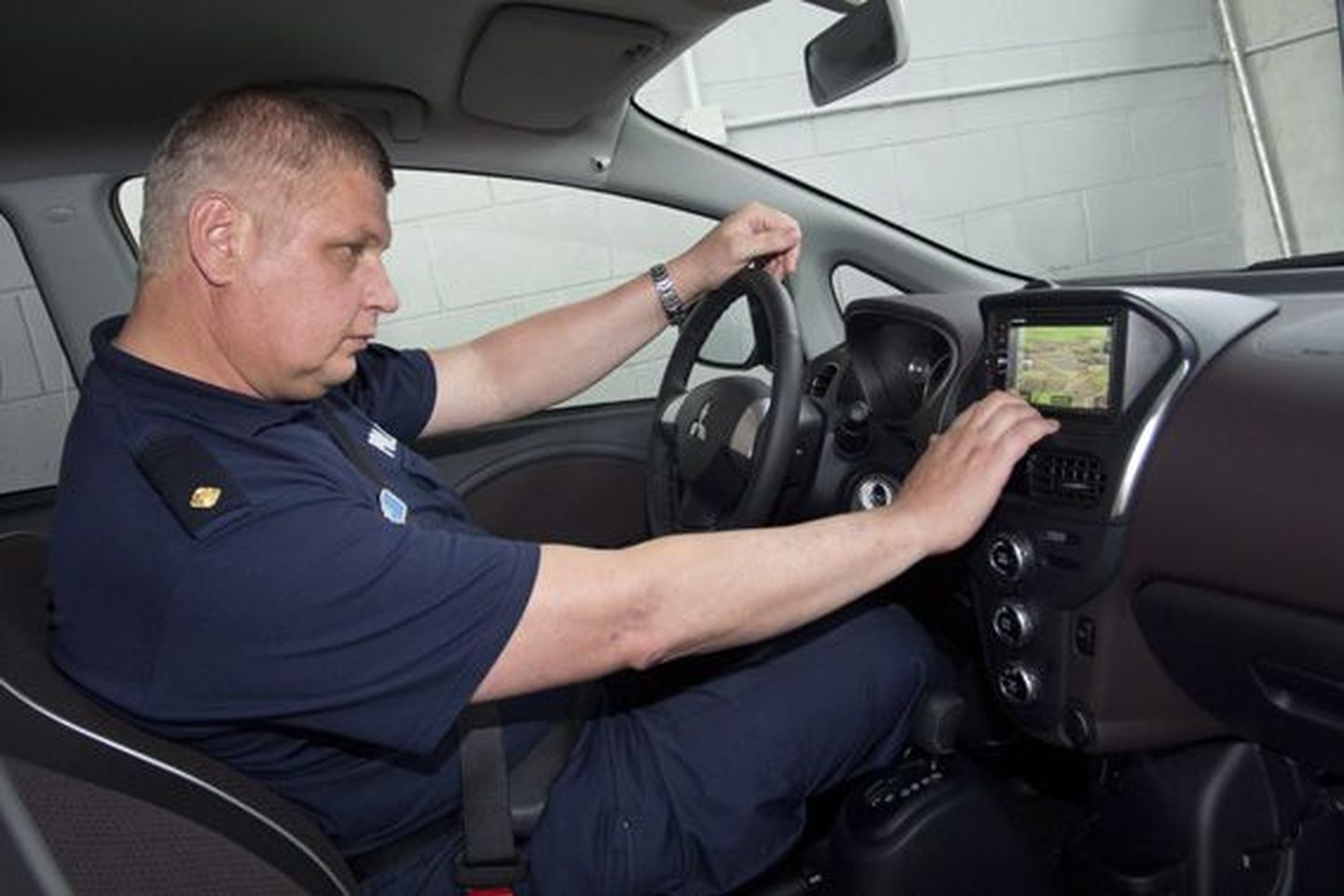 Vanemväärteomenetleja Arnas Jõe uurib navigatsiooniseadet, mis eritellimusena paigaldati politsei elektriautodele.