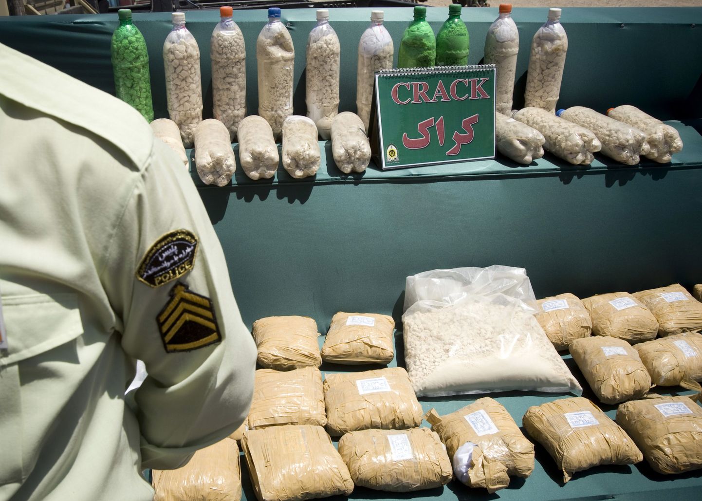 Iraani narkopolitseinik konfiskeeritud mõnuainete juures.