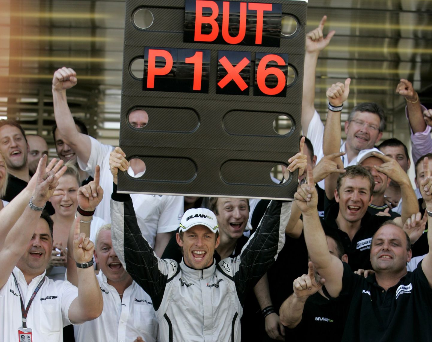 Jenson Button vallatles eile pärast võitu koos meeskonna ning võistluse ajal tulemusi näitava tahvlikesega.