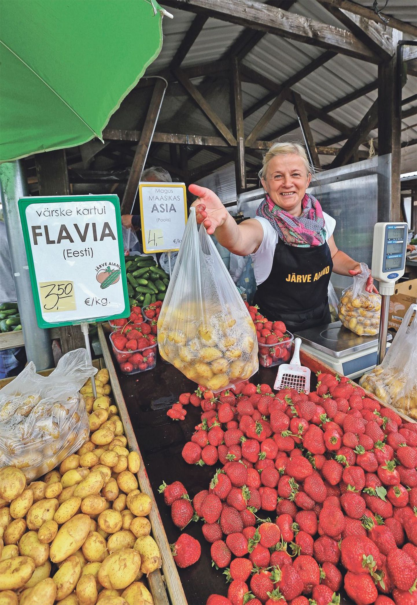 Järve aiandi müüja Maarika Kivi ulatab ostjale kodumaiseid värskeid kartuleid.
