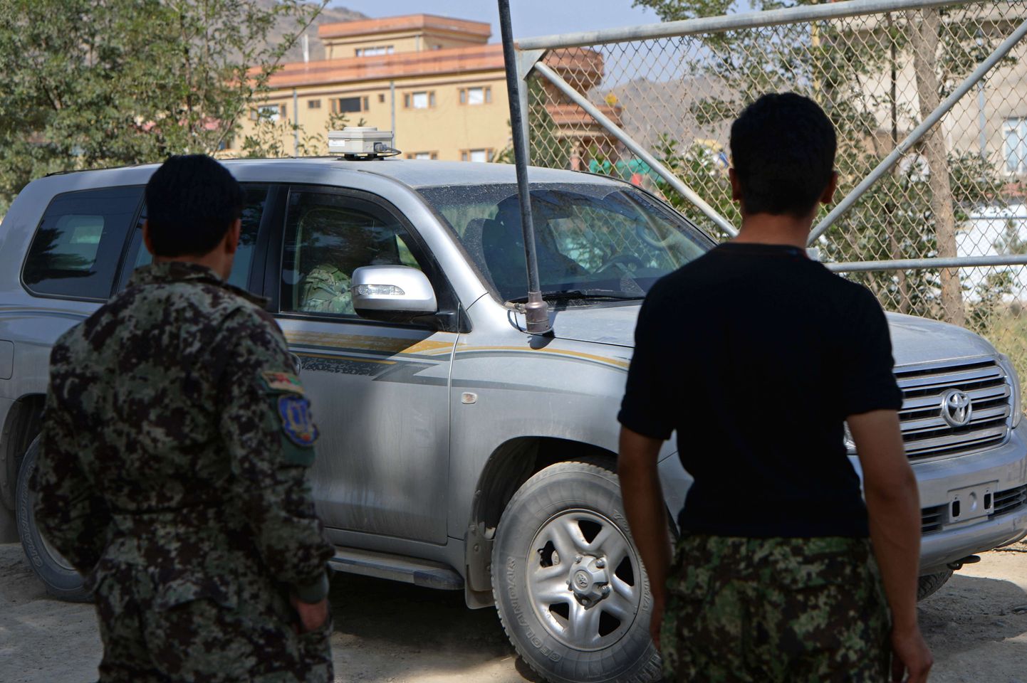 Afgaani sõdurid vaatavad, kuidas NATO masinad sõjaväeakadeemia juurest lahkuvad.