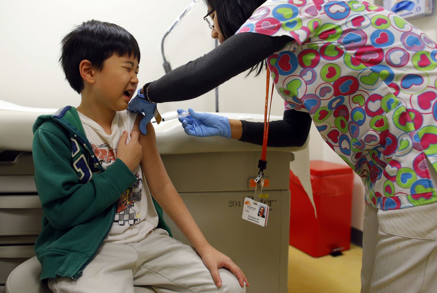 Õde last gripi vastu vaktsineerimas.