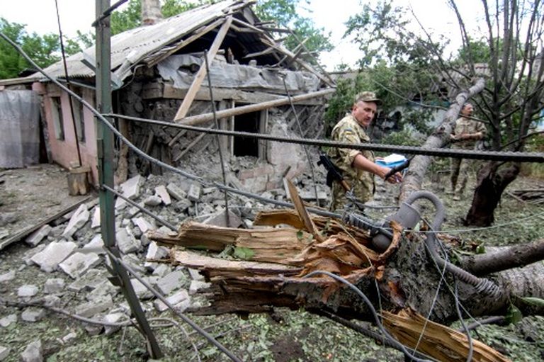 Иллюстративное фото. Украинский военный рассматривает разрушения в деревне Ольгинко, июнь 2017 года 