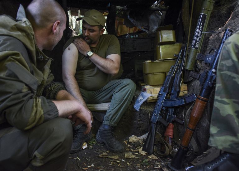 Isehakanud Donetski Rahvavabariigi eest võitlev Vene-meelne separatist näitab kaasvõitlejale oma armi. / Scanpix