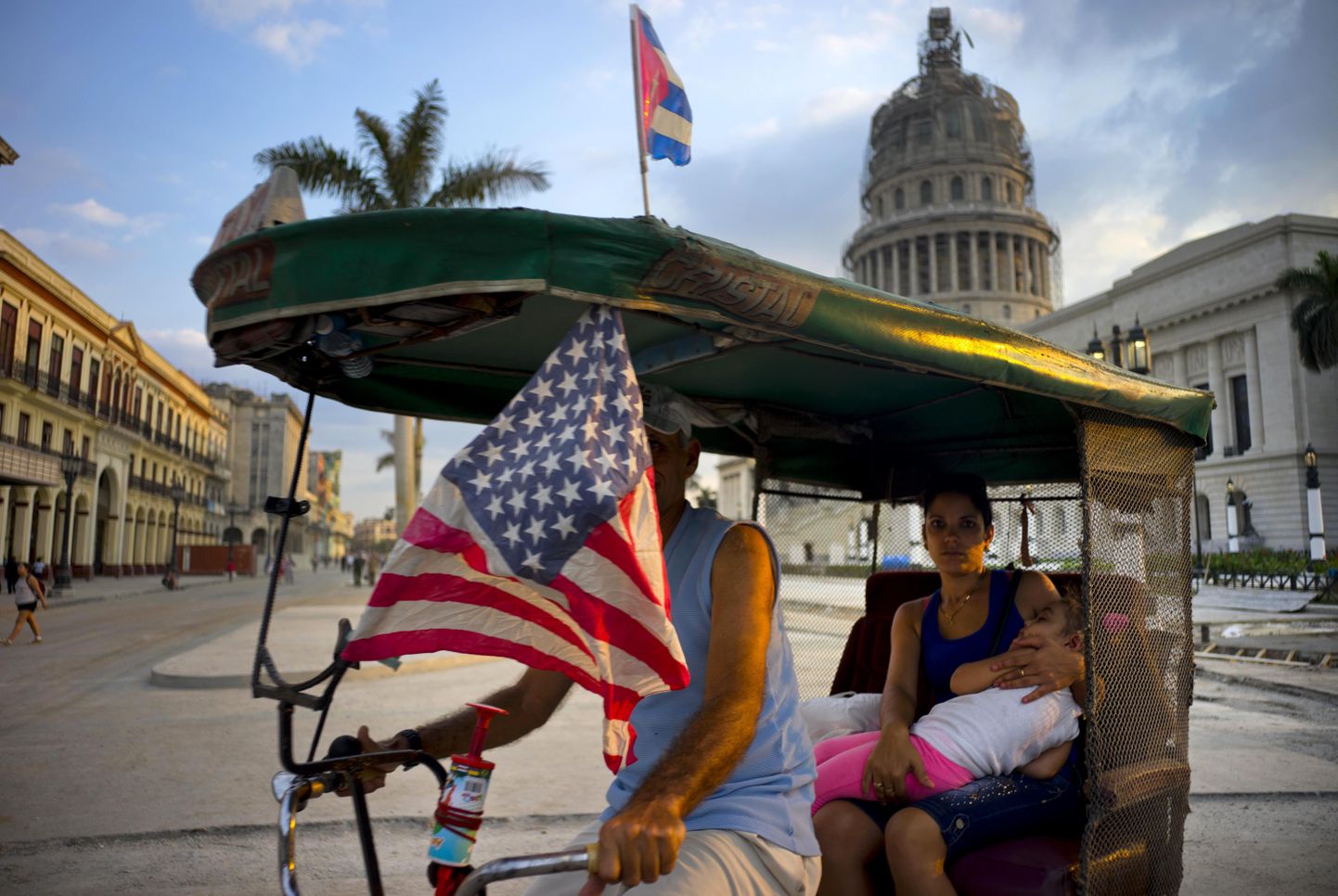 Kuuba ja USA lippudega dekoreeritud velotakso Havanna kesklinnas.