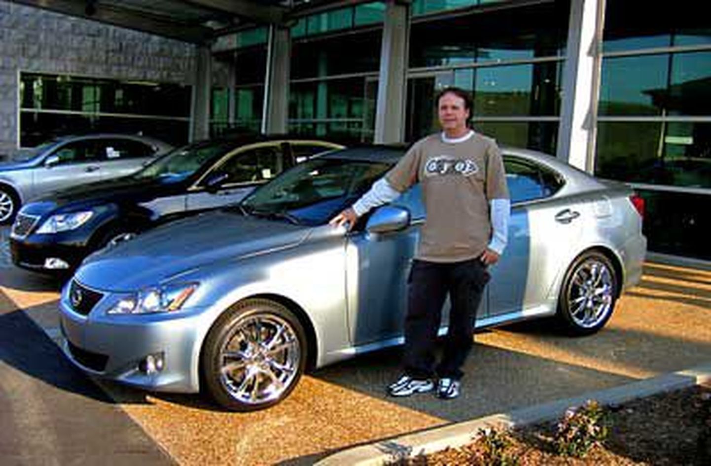 Мужчина позирует со своим Lexus, купленным на "выигранные" деньги.