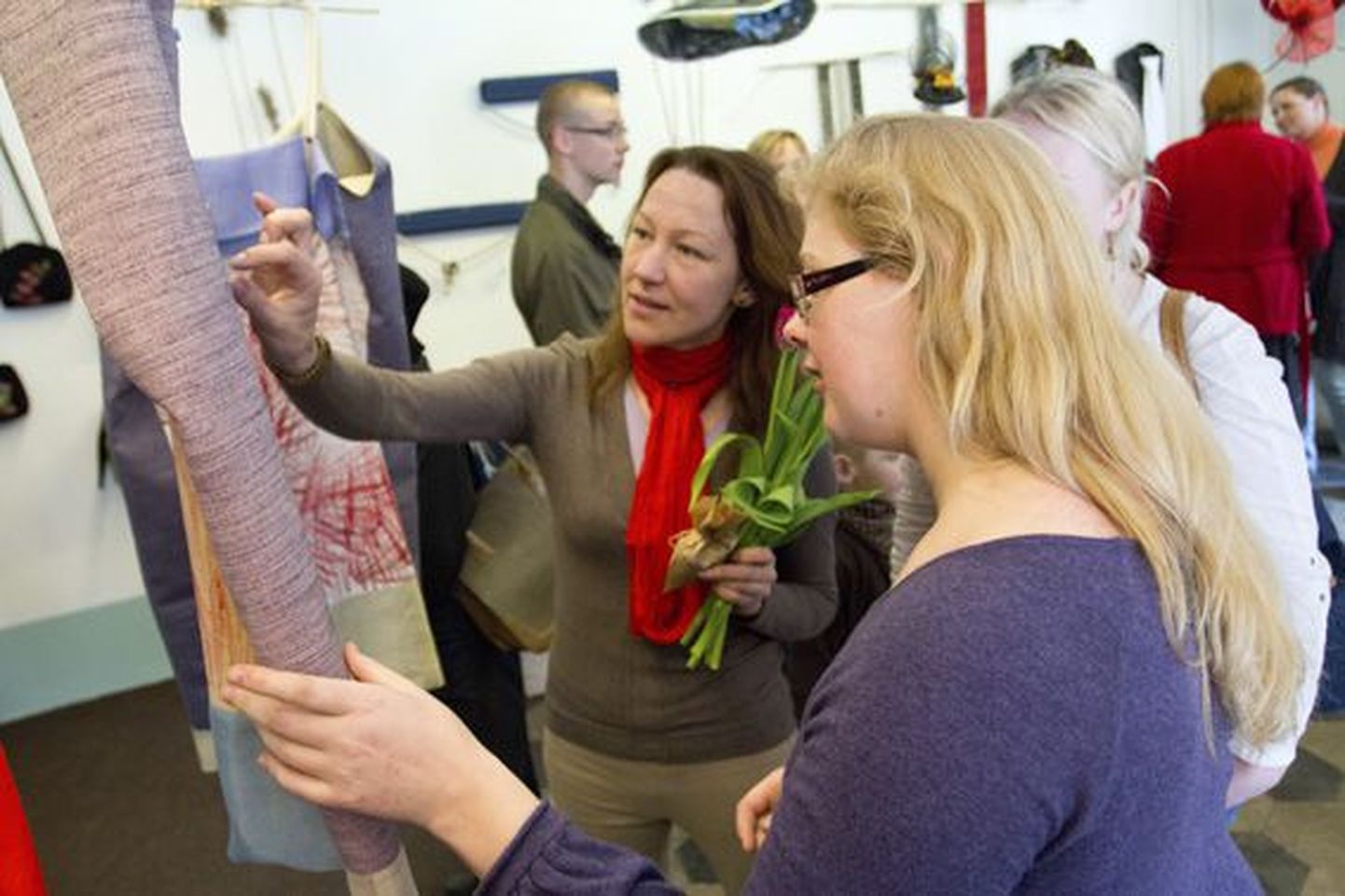 Kleitide looja Kärt Karjatse (keskel) juhib tähelepanu huvitavatele kangastele.