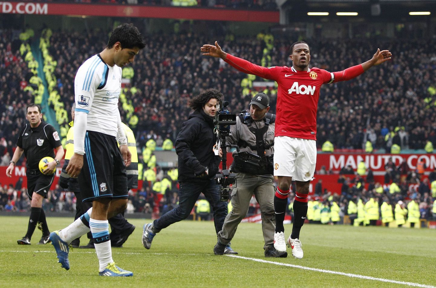 Manchester Unitedi kaitsja Patrice Evra võidu üle rõõmustamas. Vasakul on Liverpooli ründaja Luis Suarez.