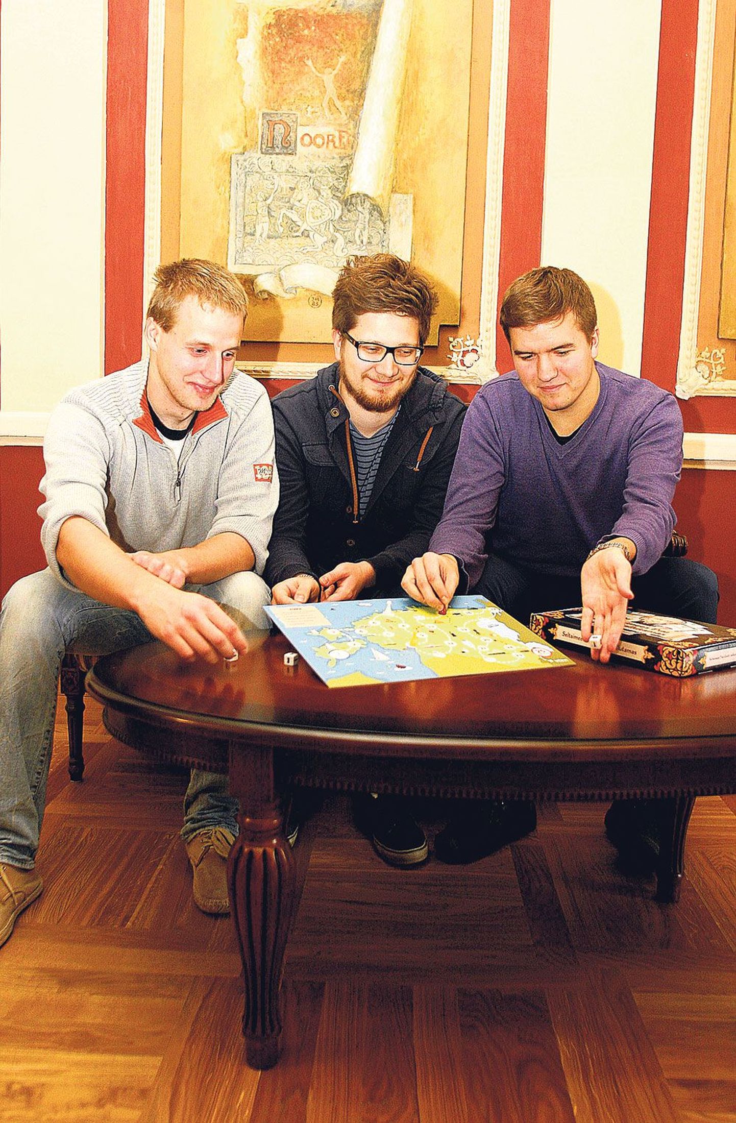 Tudengid Taavi Emajõe (vasakult), Argo Ingver ja Madis Sulg on mängulaua juba kätte saanud. Selle nädala jooksul ootavad nad trükist veel mängukaarte, et õige pea hakata toodet müüma.