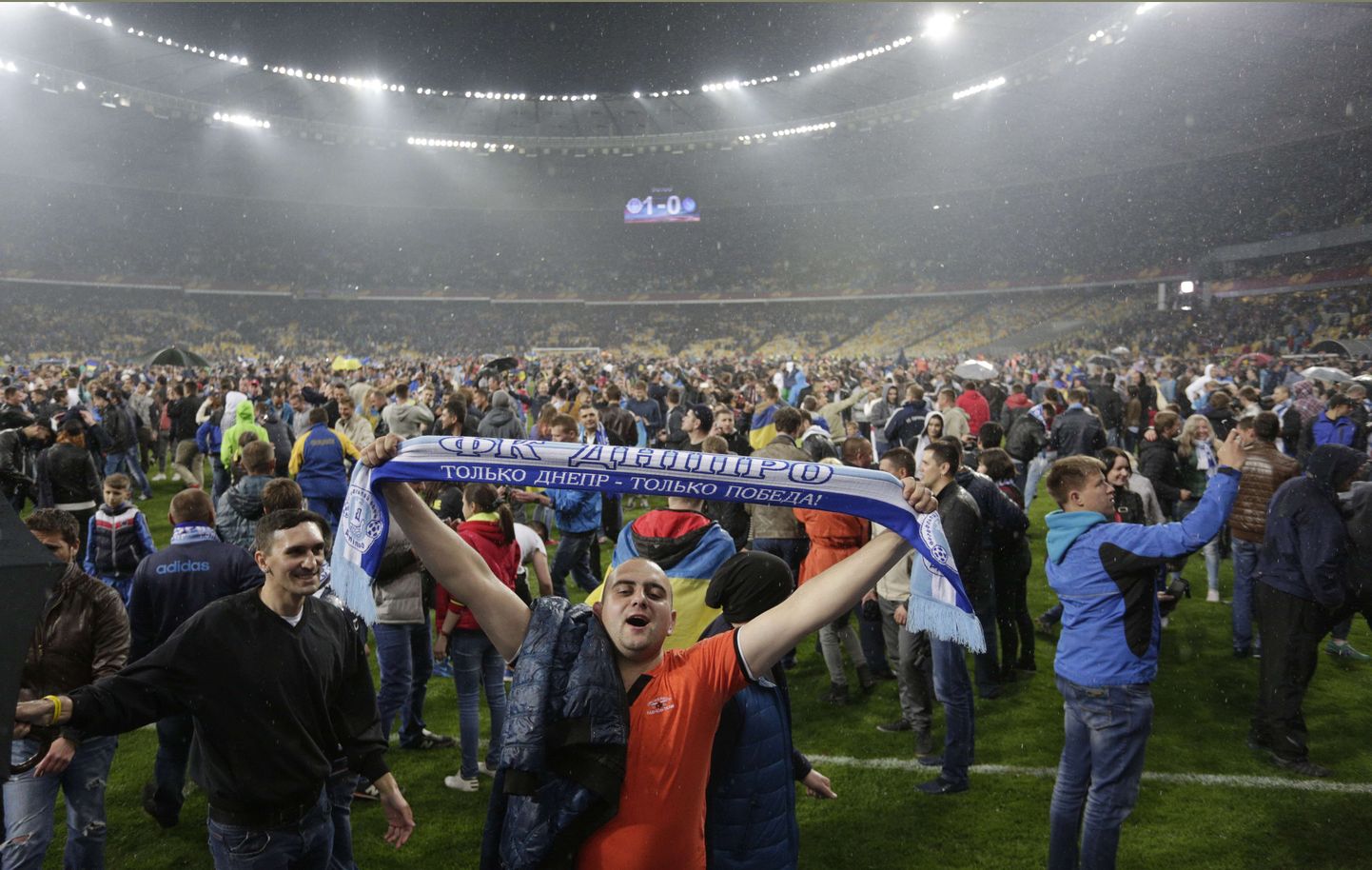 Болельщики "Днепра" празднуют выход в финал на поле стадиона в Киеве.