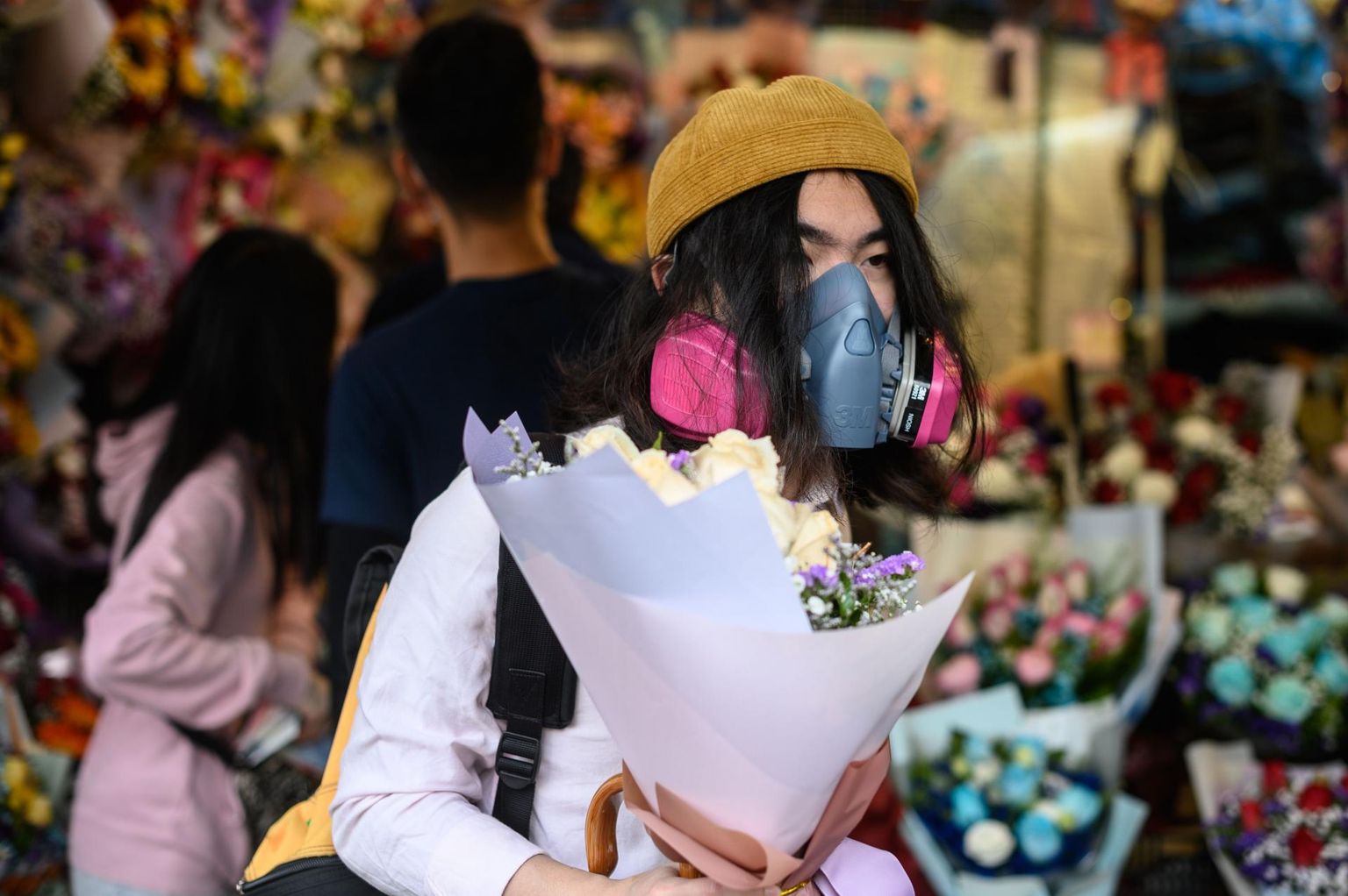 Respiraatoriga end viiruse Covid-19 eest kaitsev mees ostmas valentinipäeval lilli Hongkongis.