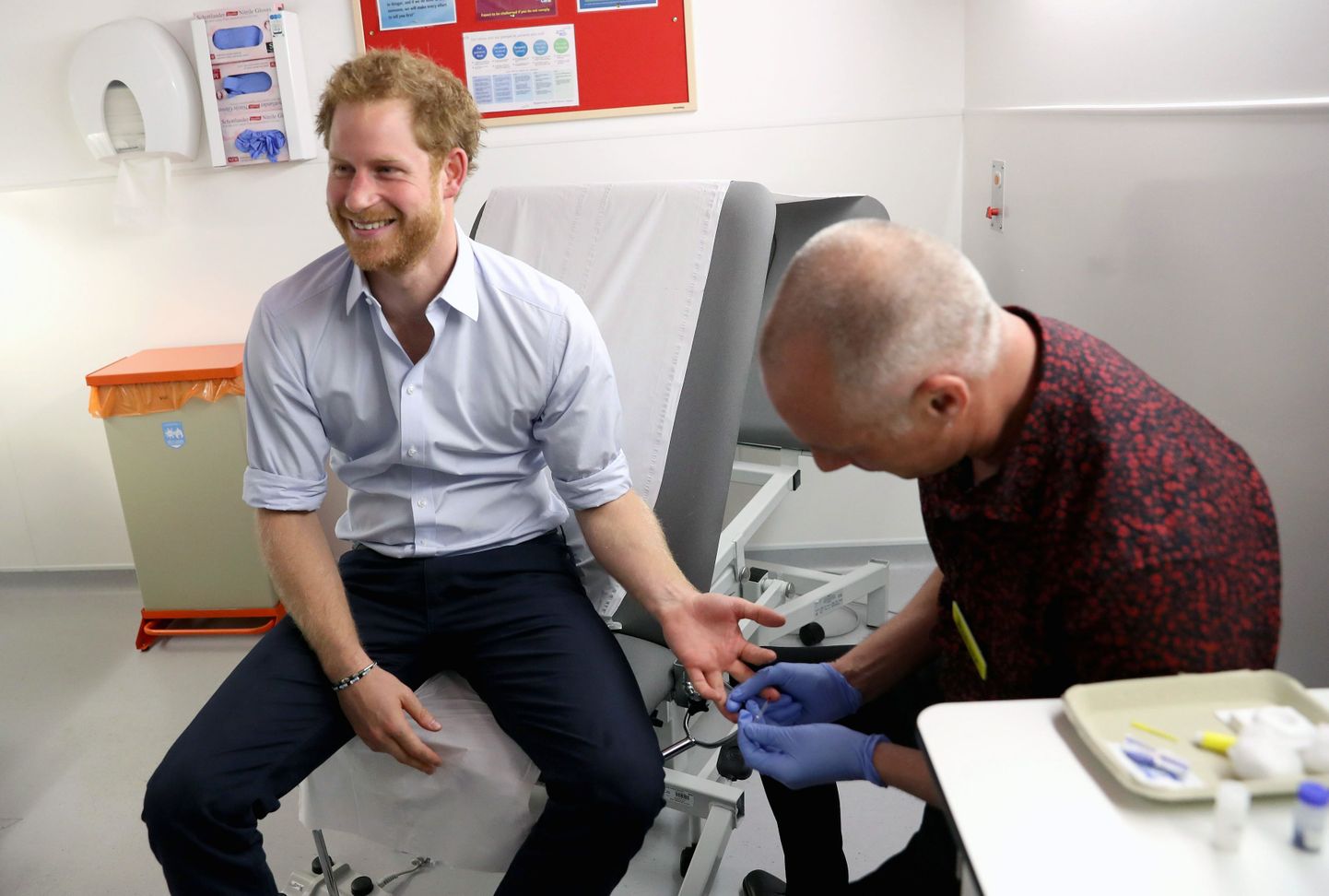 Britain's Prince Harry has blood taken for an HIV test, administered by Specialist Psychotherapist Robert Palmer during a visit to highlight the fight against HIV and AIDS, at the Burrell Street Sexual Health Centre in Southwark, London, Thursday, July 14, 2016. (Chris Jackson/PA via AP)