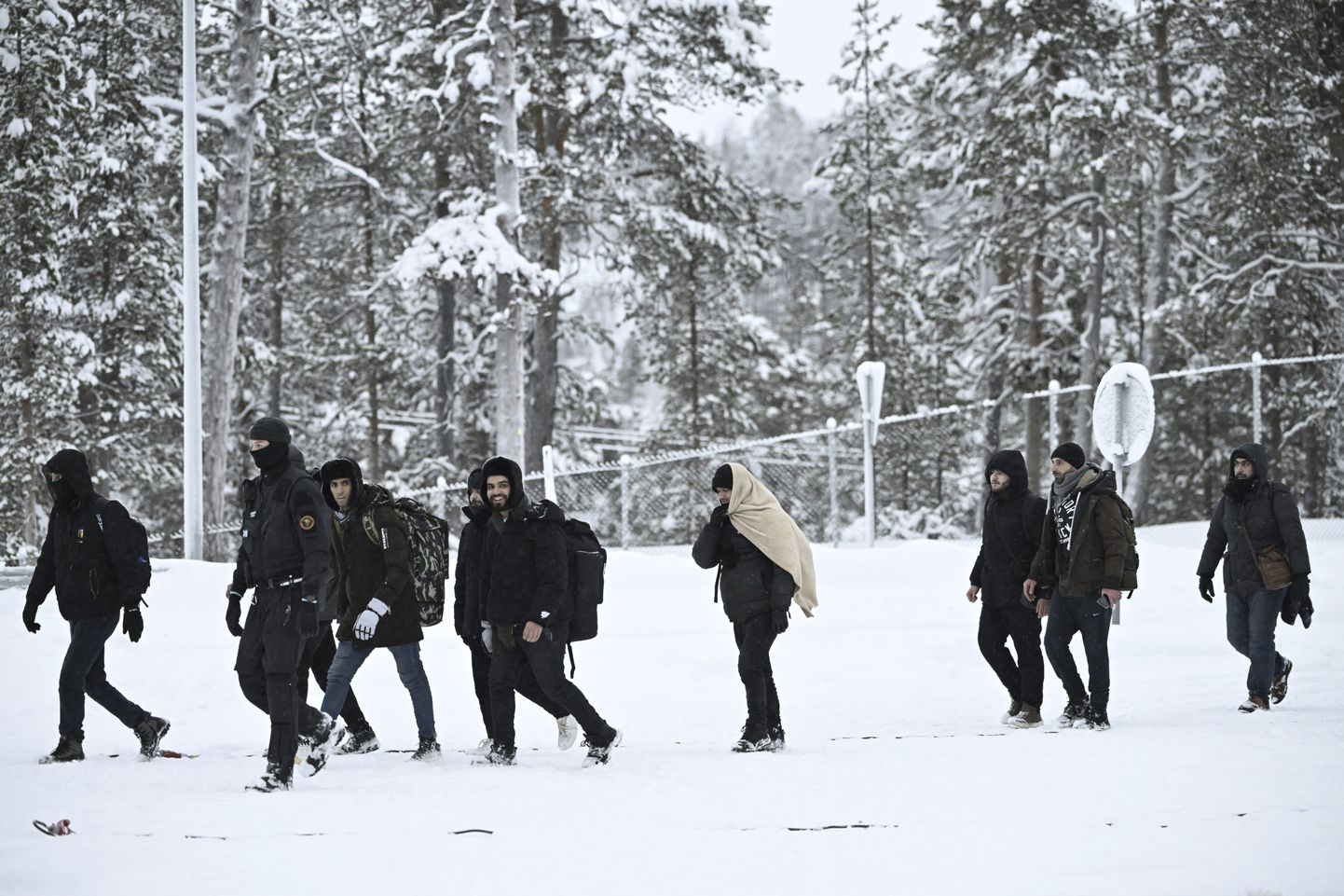 Soome piirivalvur eskortimas migrante Lapimaal Raja-Jooseppi piiripunktis. Soome sulges kogu idapiiri, mis jääb vastu Venemaad, et takistada massimigratsiooni.