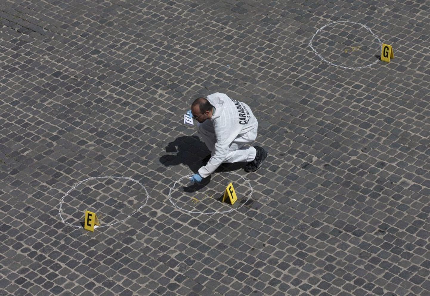 Politsei uurija kogumas tõendusmaterjali eile Roomas toimunud tulistamise kohta.