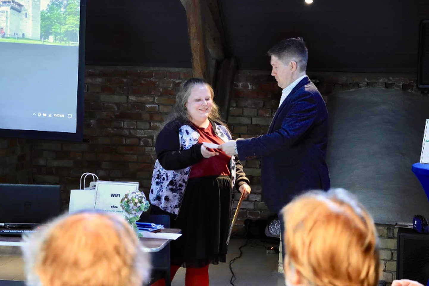 Jaana Kind võtab preemia vastu muuseumi teadusjuhilt Ründo Mültsilt.