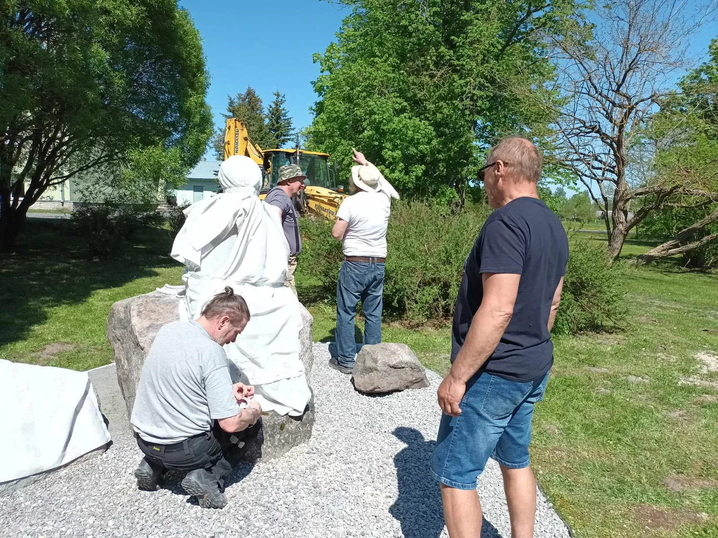 Eile pisut enne keskpäeva. Kuju on kohal, paigaldamine algab. Skulptor Simson tagaplaanil kamandamas, laia äärega kaabu peas. Esiplaanil kükitab Uus Monumentaali osaühingu juhatuse liige Andres Aotäht.