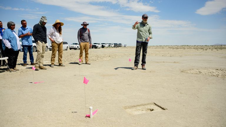This image released by the US Air Force shows Daron Duke, from Far Western Anthropological Research Group, speaking with visitors about footprints discovered on an archaeological site marked with a pin flag on the Utah Test and Training Range, on July 18, 2022. - Archaeologists working for the Air Force this month have discovered 88 human footprints preserved in the alkali flats on the Utah Test and Training Range that they believe date to more than 12,000 years ago. (Photo by Handout / HANDOUT / AFP) / RESTRICTED TO EDITORIAL USE - MANDATORY CREDIT "AFP PHOTO /  R. Nial Bradshaw /US AIRFORCE " - NO MARKETING - NO ADVERTISING CAMPAIGNS - DISTRIBUTED AS A SERVICE TO CLIENTS