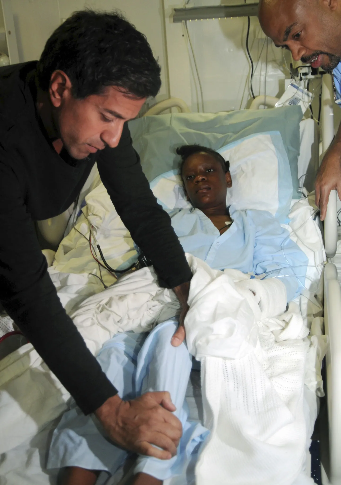 Sanjay Gupta (vasakul) vigastatud Haiti tüdrku tervist kontrollimas.