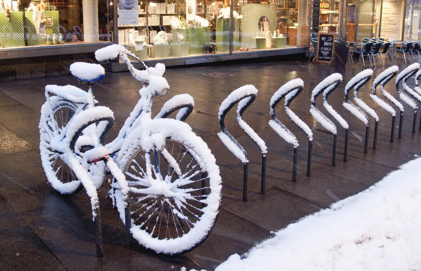 Lumega kaetud jalgratas Norra pealinnas Oslos.