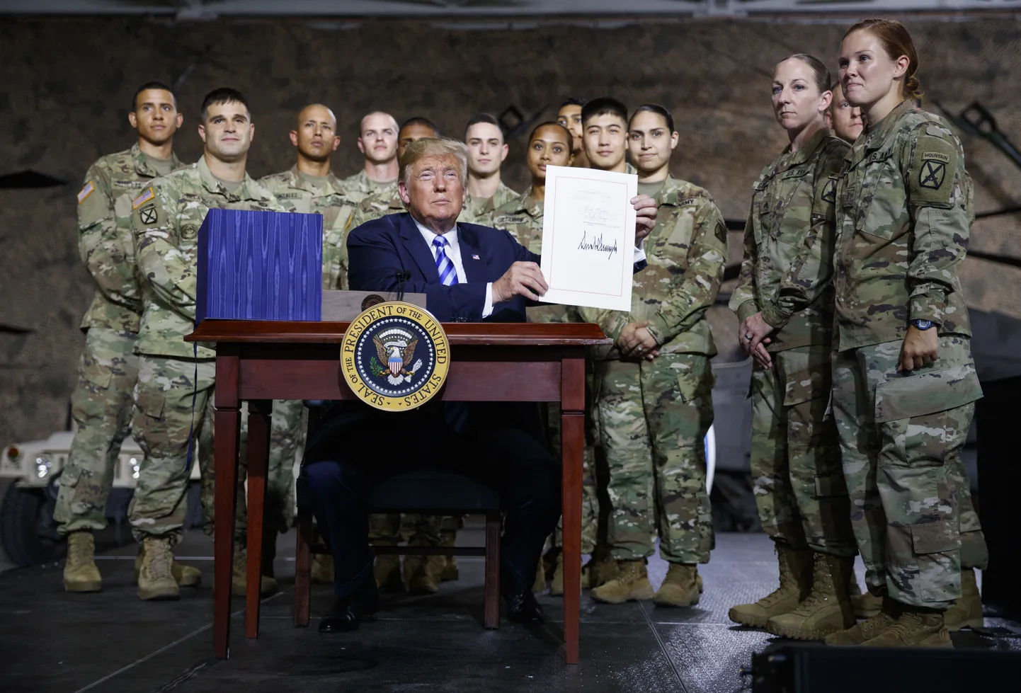Ameerika Ühendriikide president Donald Trump hoiab käes riigi kaitse-eelarve seadust.