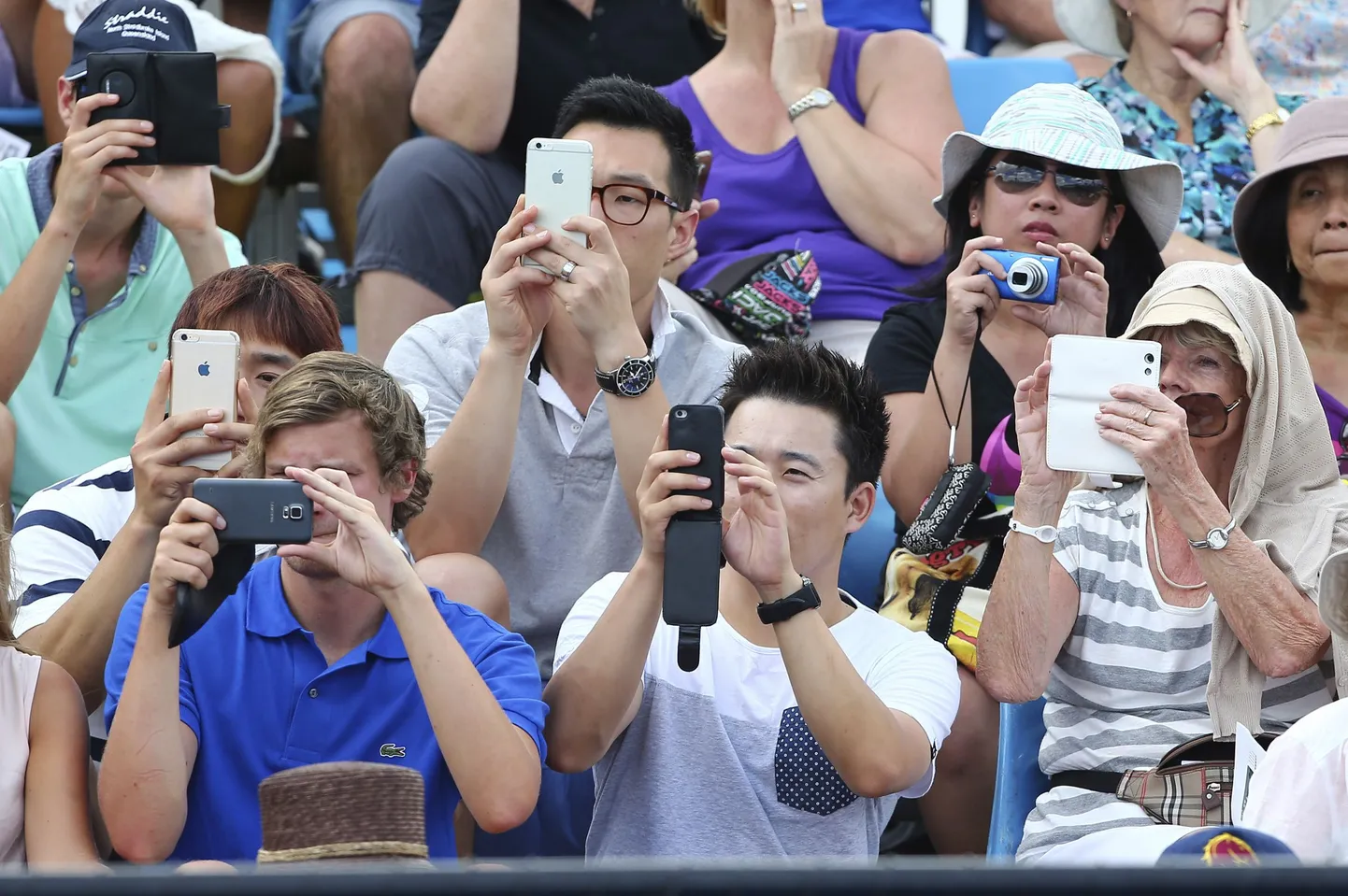 Публика фотографирует мобильными телефонами.