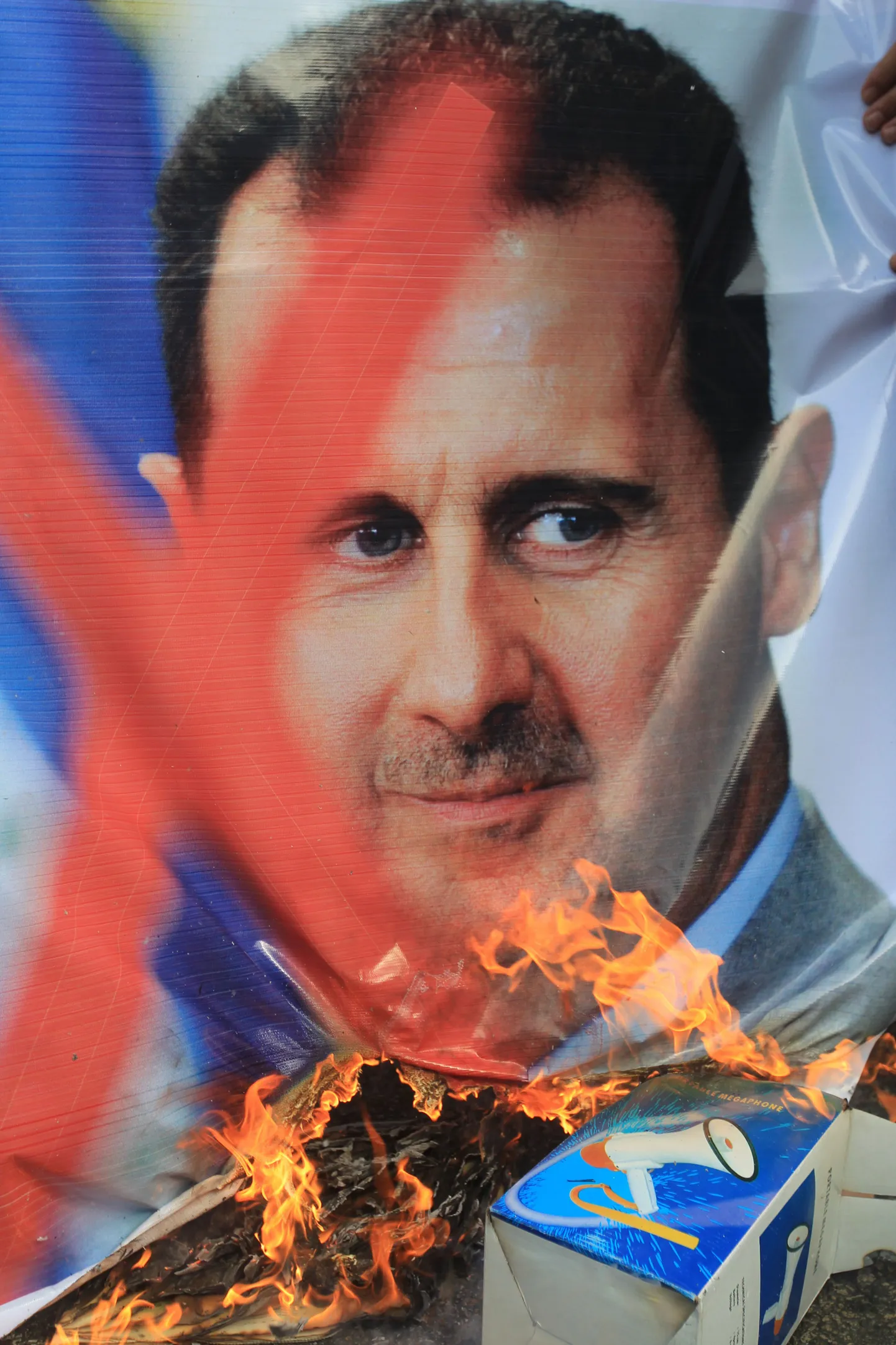 Meeleavaldajad põletamas Egiptuse pealinnas Kairos Süüria presidendi Bashar al-Assadi plakatit.
