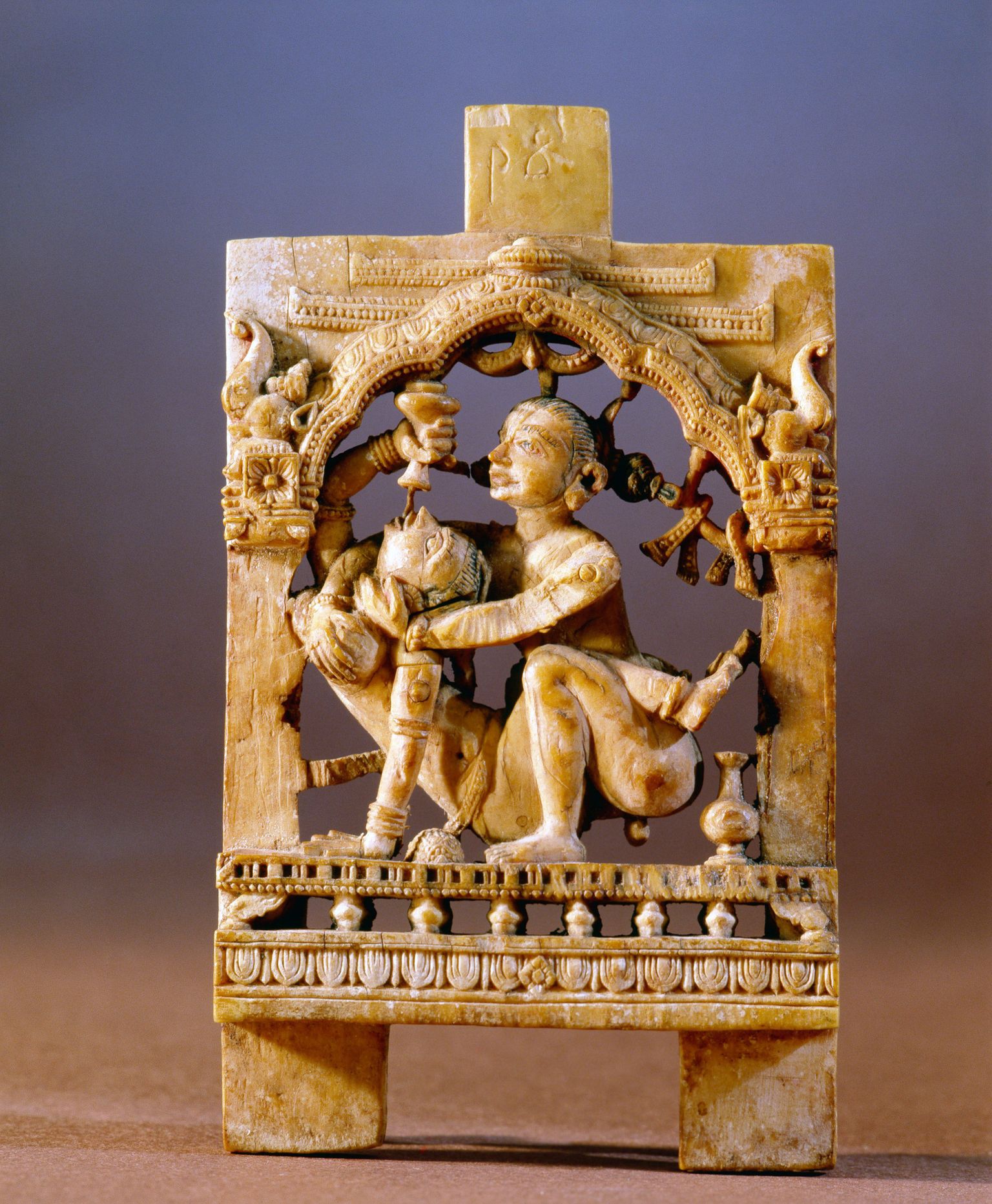 Hindu kuju mehest kinni hoidmas naist, kes pudelist joob.
