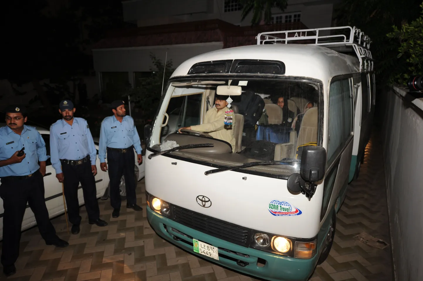 Pakistani politseinikud väikebussi juures, milles vibivad bin Ladeni kolm leske ja lapsed.