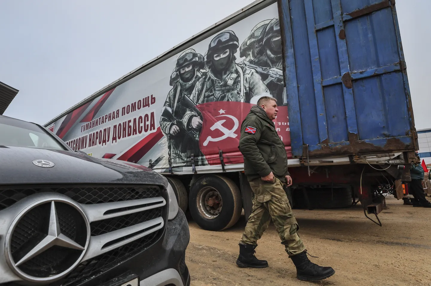 Vene kommunistliku partei toetaja patseerib 2024. aasta detsembris Vene sõdureid reklaamiva reka ees okupeeritud Ukraina aladel.
