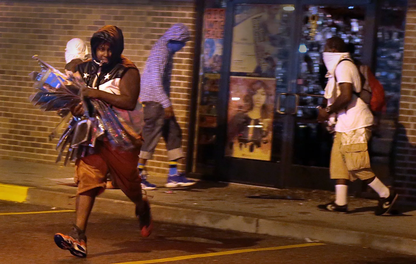 Rüüstaja täna öösel Fergusoni linnas West Florissanti avenüül, käes ilutarvete poest kätte saadud kaup.