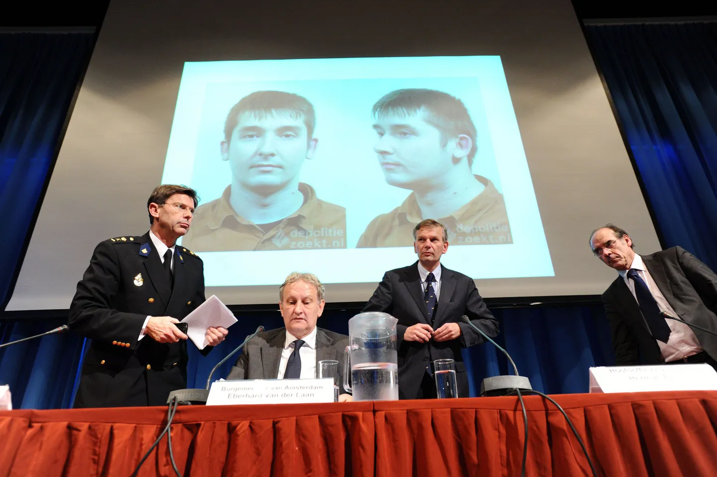 Linnavõimud pressikonverentsil Amsterdami raekojas, taamal süüaluse pedofiili fotod.