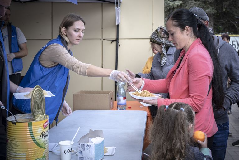 Cilvēkiem Zaporižjā brīvprātīgie dala maltītes.