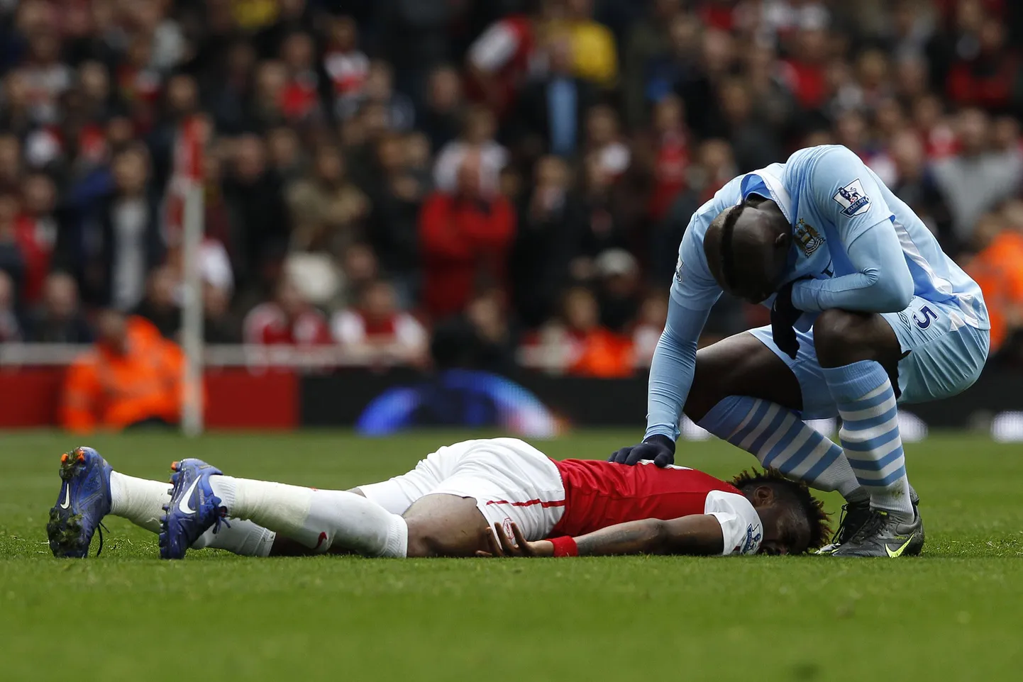 Mario Balotelli pärast jõhkra vea tegemist Alex Songilt vabandust palumas.
