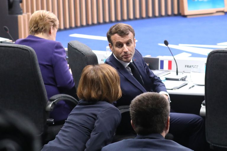 Prantsusmaa president Emmanuel Macron tagumises pingis istujale märkmeid edastamas.