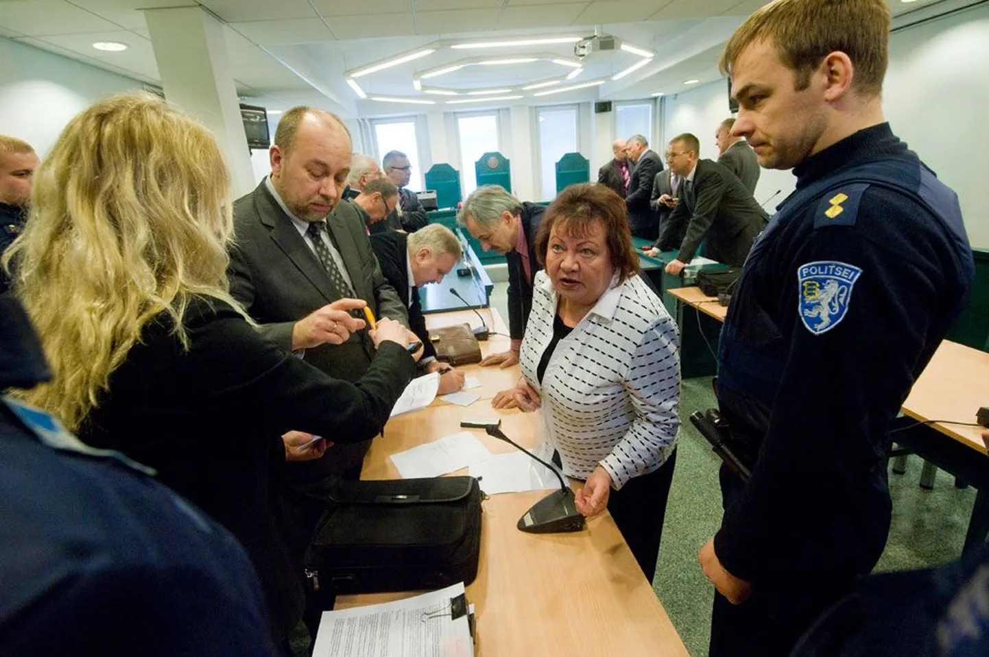 Otsus on ette loetud, kohtusekretär võtab Ivo Parbuselt allkirja ja süüaluse kaitsja Marina Leis (keskel) jagab viimaseid nõuandeid. Politseinik ootab, et saaks Parbuse ära viia.