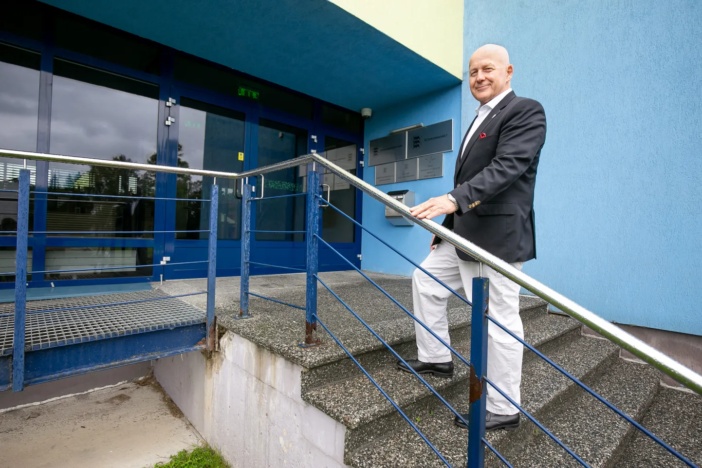 Keskkonnainspektsiooni juht Peeter Volkov endise Põllumajandusprojekti pika ja uue kuue saanud hoone trepil.