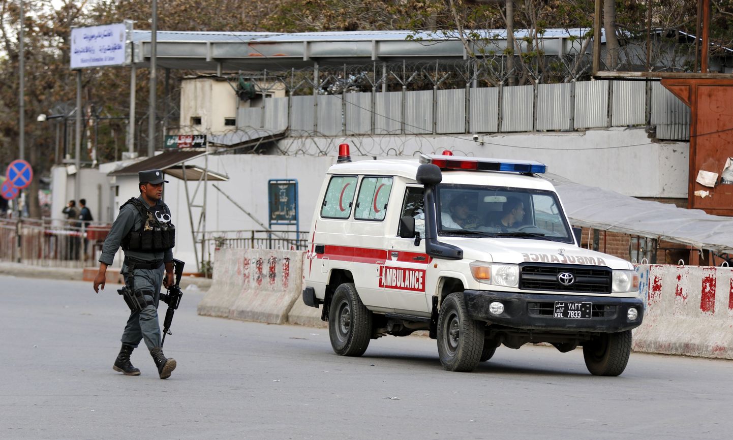 Politseinik ja kiirabiauto Kabulis asuva ministeeriumihoone ligidal.