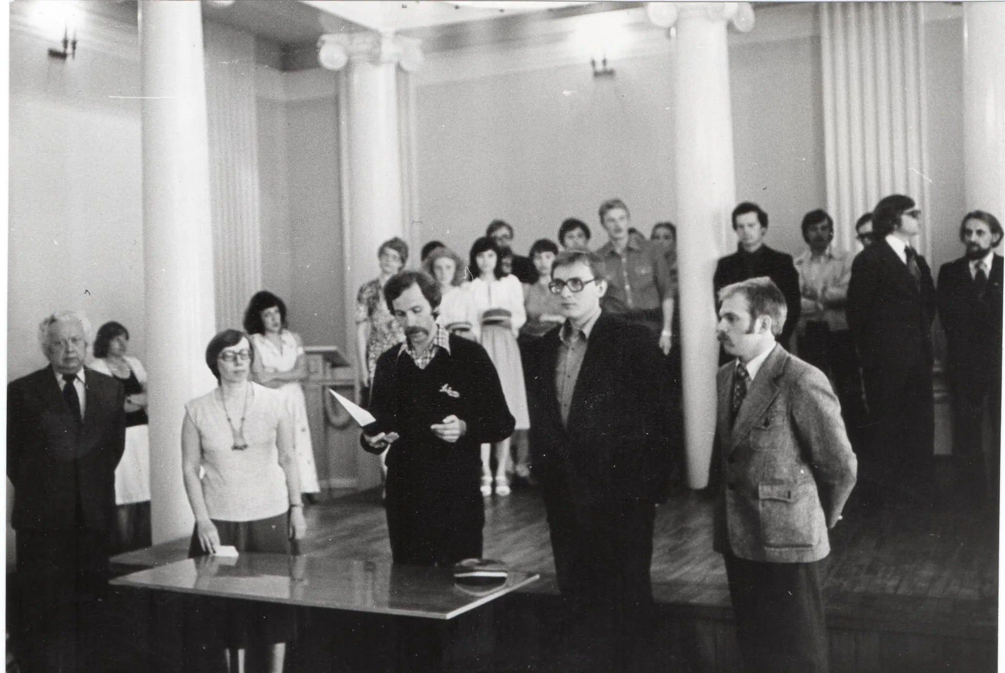 1981. aasta mai žurnalistikaosakonna päev aulas, kus Academia Peegeliana eetikakoodeksit loeb ette viienda kursuse tudeng Erki Berends. Tema kõrval seisavad õppejõud Juhan Peegel ja Marju Lauristin ning teisel pool üliõpilased Tiit Matsulevitš ja Hannes Tamme. Sammaste vahel need, kes tõotuse juba andnud.