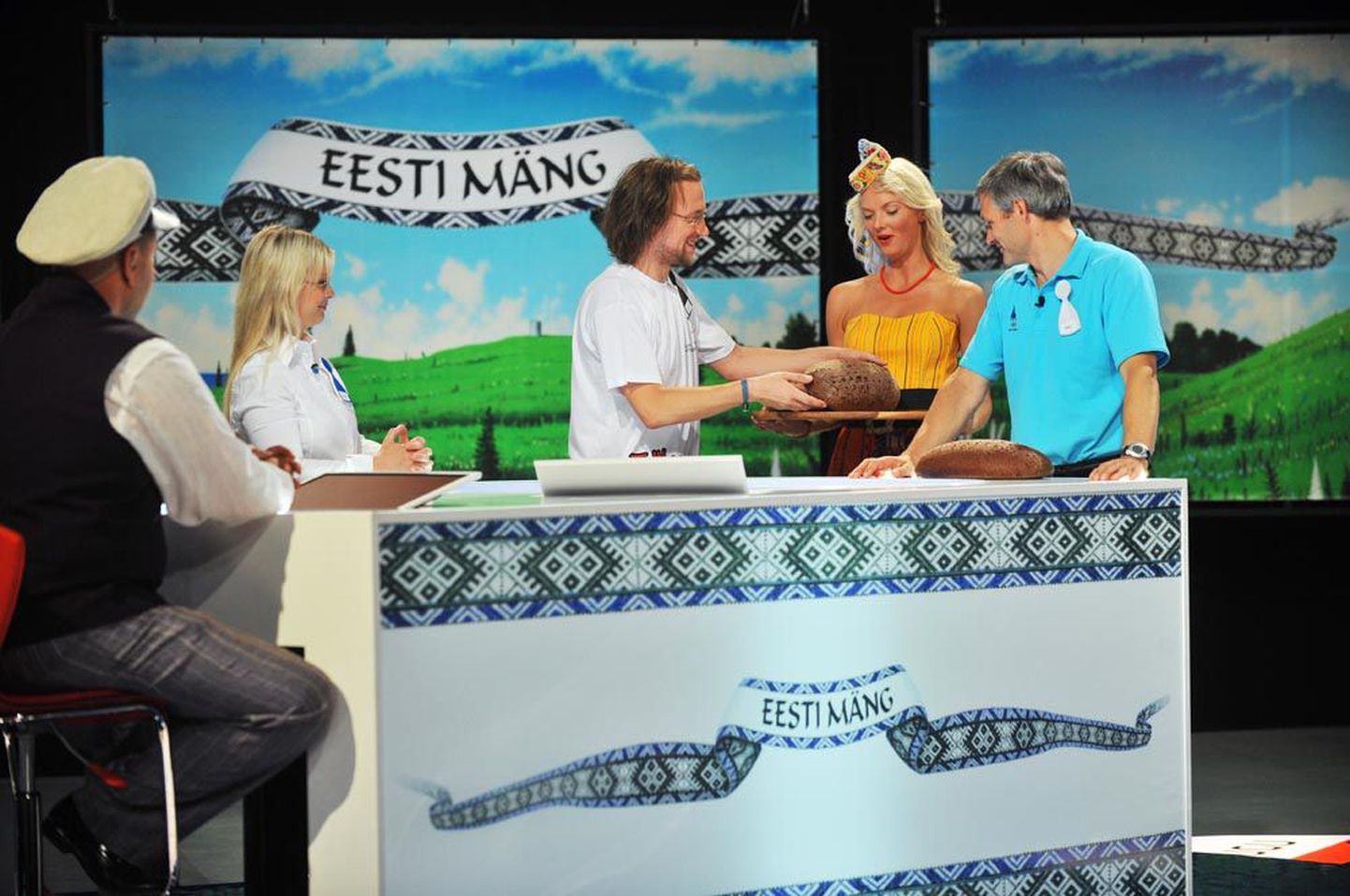 Esimeses mängus said kõik osalejad – Kadri Tali (taga vasakult), Märt Agu ja Erki Nool – tulemusest hoolimata saatejuht Gaute Kivistiku (ees vasakul) rahvariideainelises kostüümis abiliselt autasuks mehise pätsi eestimaist rukkileiba.