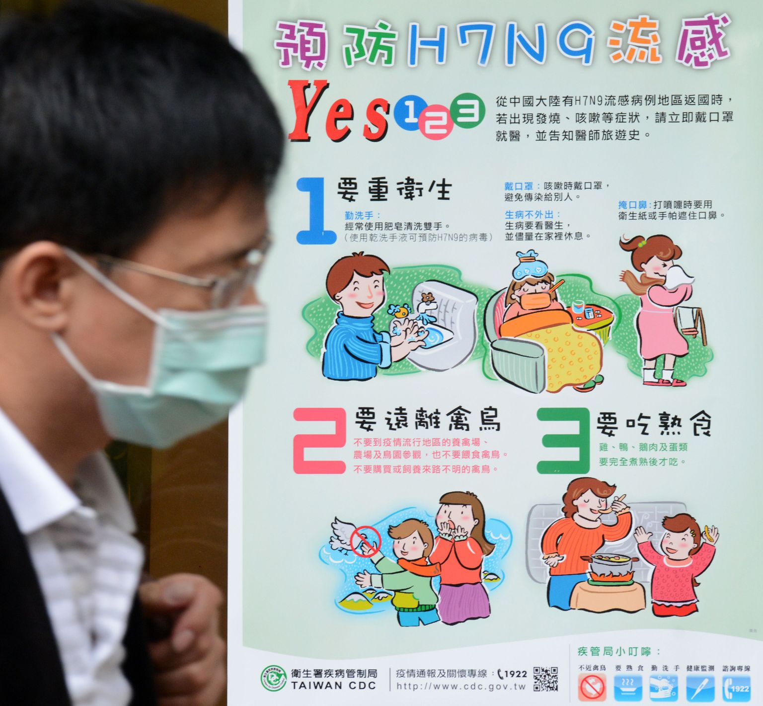 Maskiga mees linnugripi H7N9 ennetamise võimalusi tutvustava plakati juures Taipeis.