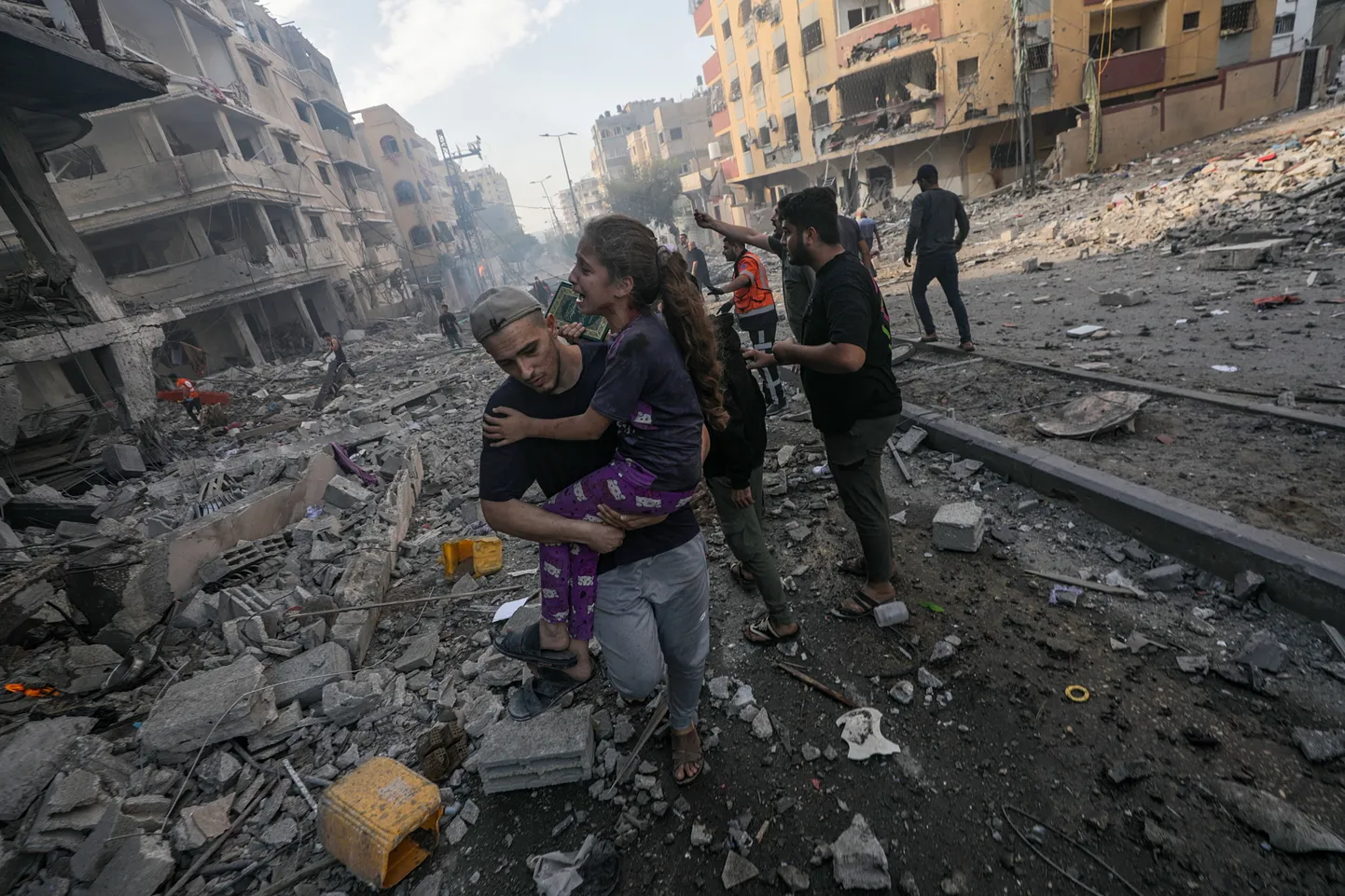 Mees kandmas süles haavatud tüdrukut pärast Iisraeli õhurünnakut Gazas  21. oktoobril.