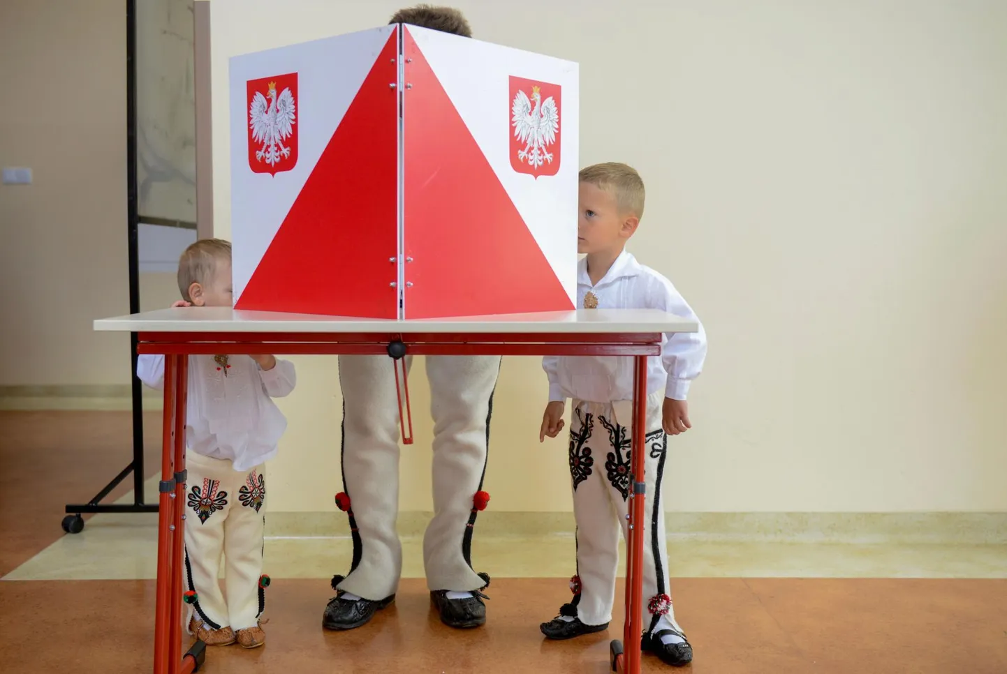 Poola rahvariideid kandvad poisid hoidmas Zabi valimisjaoskonnas silma peal sellel, kelle poolt nende isa oma hääle annab.