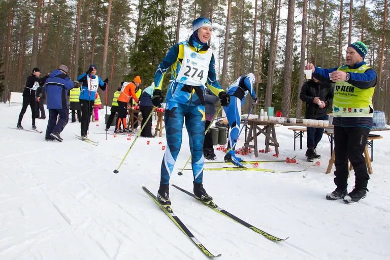Toitlustuspunkti ülem Peeter Maala on ulatamas joogitopsi Eesti eelmisele presidendile Kersti Kaljulaidile, kes läbis suuskadel Pannjärvel öömaratonil ja põhimaratonil kokku 66 kilomeetrit.
