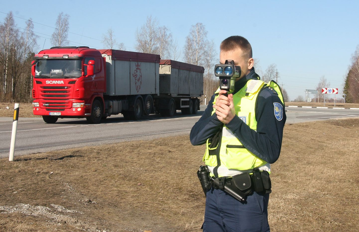 Полицейский измеряет скорость движения на дороге.