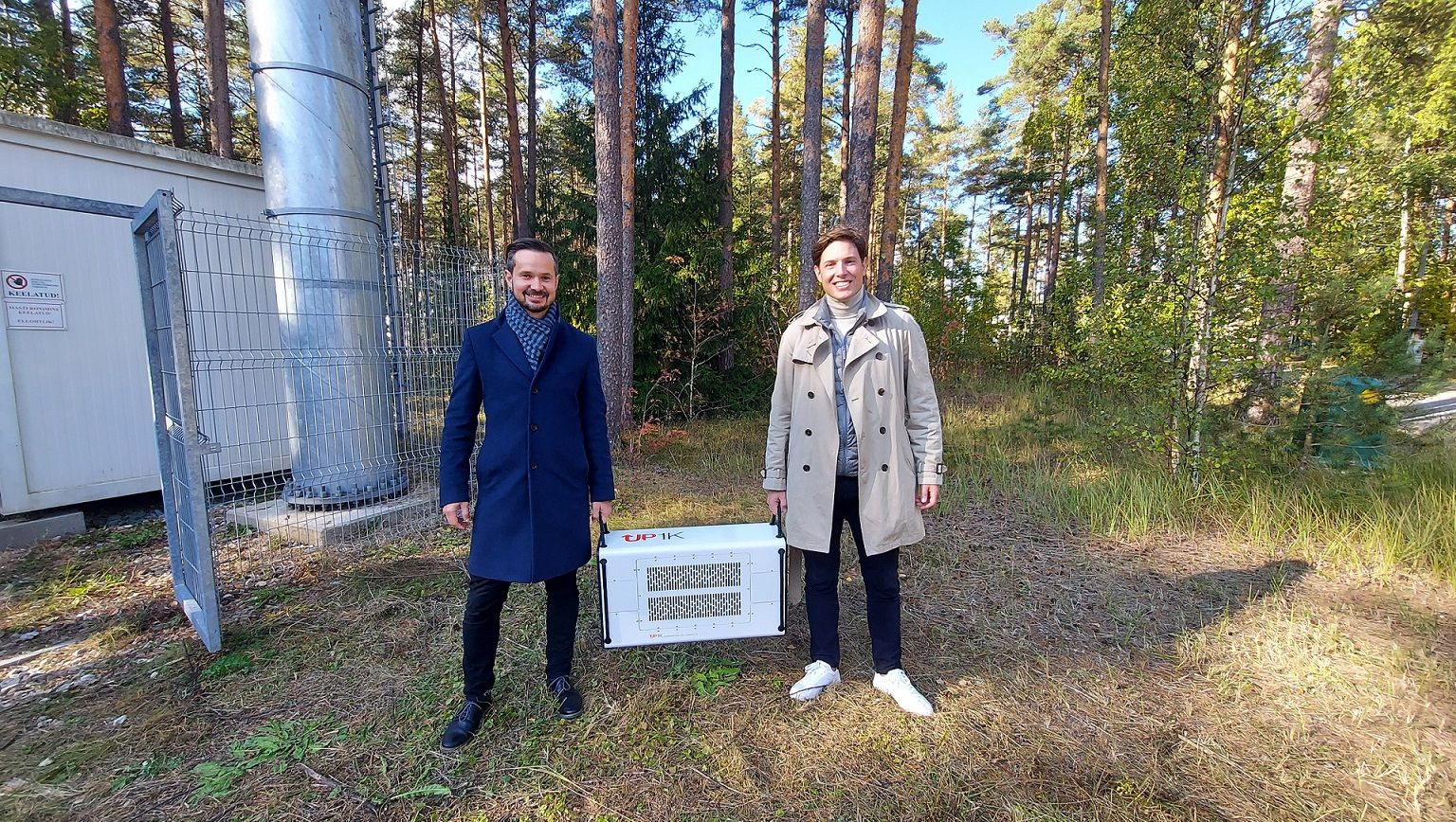 Telia tehnoloogiajuht Andre Visse ja PowerUP Energy Technologies asutaja Ivar Kruusenberg kannavad uut vesinik-generaatorit, mis kaalub vaid 26 kg.