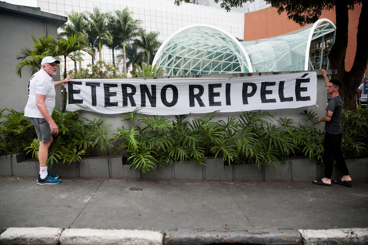 Люди скорбят. Баннер, на котором написано "Вечный король Пеле", растянут перед больницей Альберта Энштейна, в которой Пеле проходил лечение.